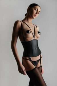 L'ensemble de lingerie en simili cuir de la collection Chambre noire de la marque Maison close porté par une femme