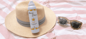 Un chapeau d'été et une paire de lunettes de soleil et une mousse de massage sensuel posés sur une table